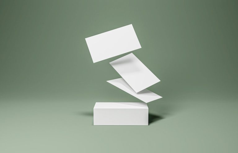 Vier weiße Karten schweben über einem rechteckigen Block auf einem grünen Hintergrund.
