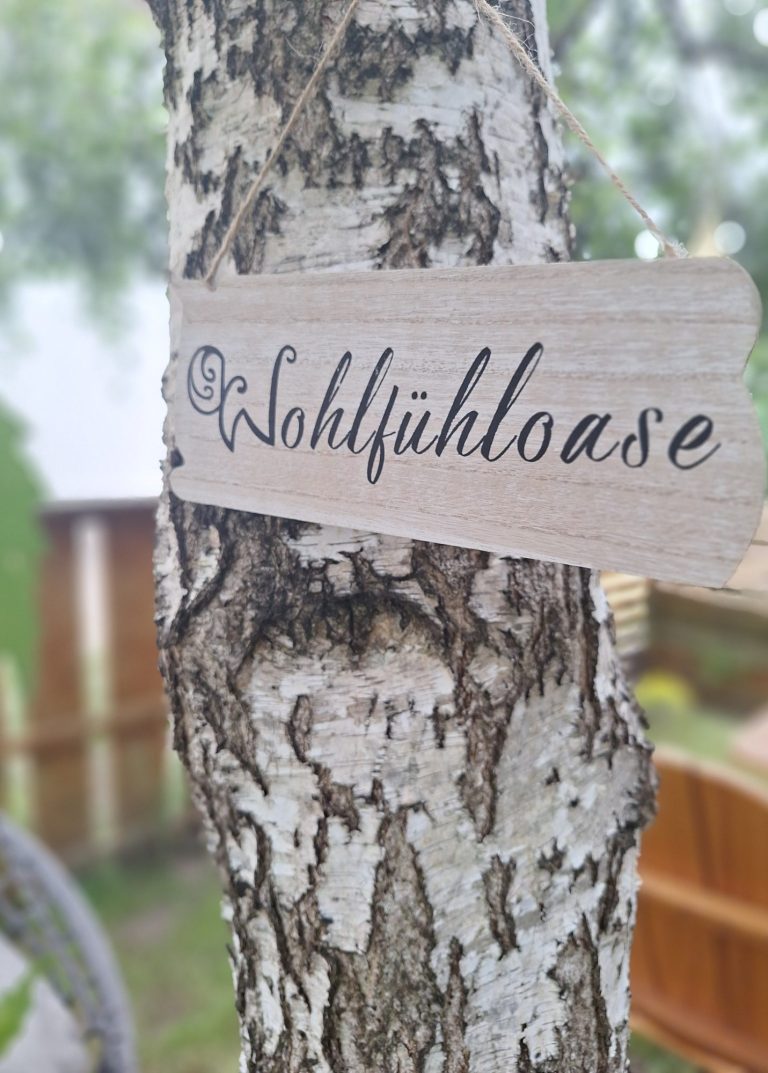 Birke mit einem Schild mit dem Titel Wohlfühloase aus meinem Garten.