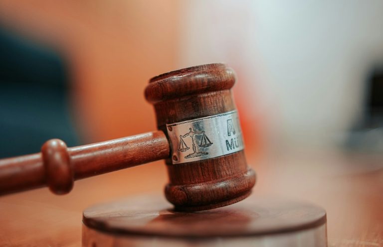 Holzhammer auf einem Tisch, symbolisiert Recht und Gericht.